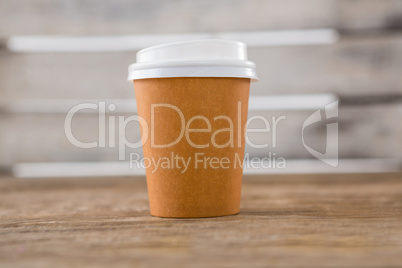 Disposable coffee cup on wooden table