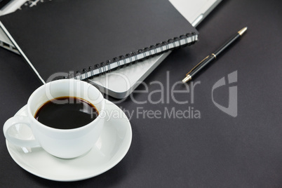 Cup of coffee, diary, laptop and pen