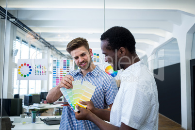 Graphic designer discussing over color swatch with a colleague
