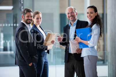Happy businesspeople standing in office lobby