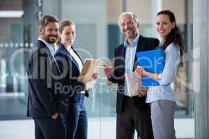 Happy businesspeople standing in office lobby