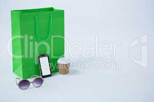 Shopping bag with sunglasses and mobile phone