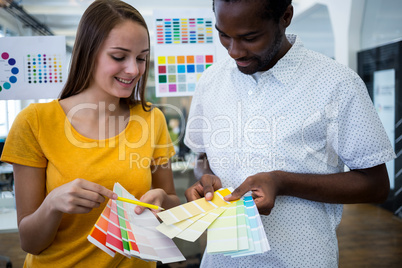 Graphic designer discussing over color swatch with a colleague