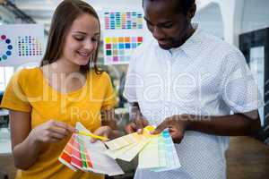 Graphic designer discussing over color swatch with a colleague