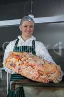 Female butcher holding raw meat at meat factory