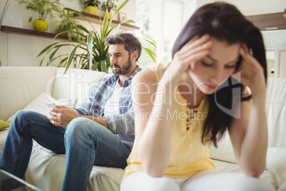 Upset couple ignoring each other on sofa