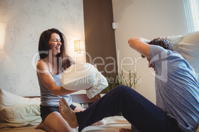 Couple having a pillow fight on bed