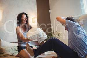 Couple having a pillow fight on bed