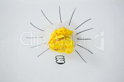 Light bulb drawn around crumbled Yellow paper