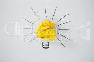 Light bulb drawn around crumbled Yellow paper