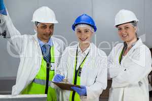 Team of technicians standing in meat factory