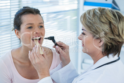 Doctor examining patients teeth with otoscope