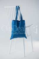 Blue bag hanging on a white chair