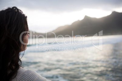 Thoughtful woman standing on beach