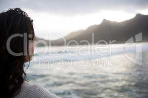 Thoughtful woman standing on beach