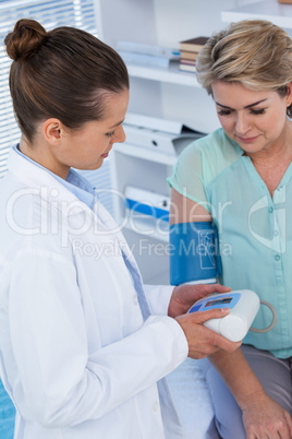 Female doctor checking blood pressure of a patient