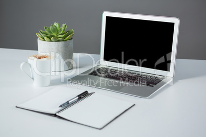 Laptop with cup of coffee and diary