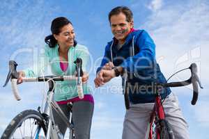 Couple leaning on bicycle while interacting with each other