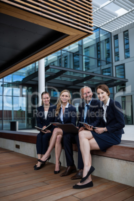 Businesspeople sitting with laptop in office premises