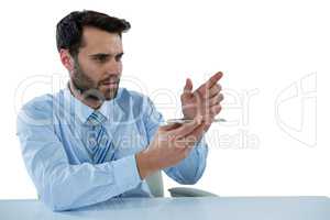 Businessman pretending to touch an invisible object at desk