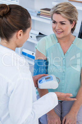 Female doctor checking blood pressure of a patient