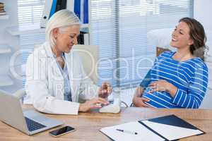 Female doctor checking blood pressure of a patient