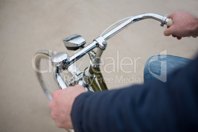 Mid section of man riding bicycle on beach