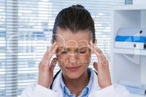 Tired female doctor having headache