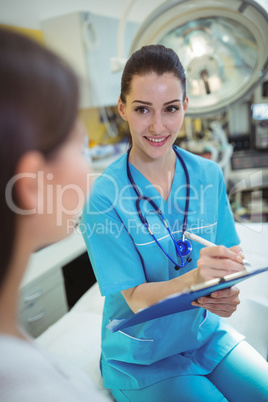 Female nurse writing on clipboard