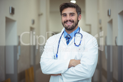 Portrait of male doctor standing in corridor