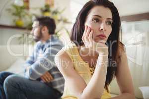 Upset couple ignoring each other on sofa