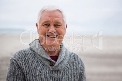 Smiling senior man standing at the beach