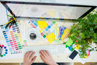 Graphic designer working on computer at his desk