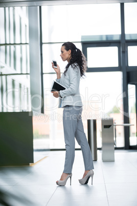 Businesswoman holding digital tablet and mobile phone