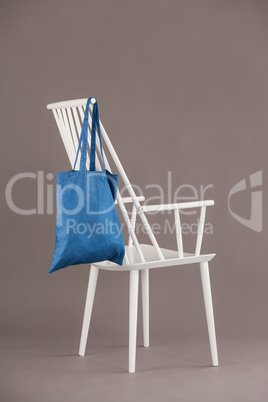 Blue bag hanging on a white chair