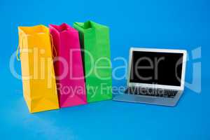 Colorful shopping bags with laptop