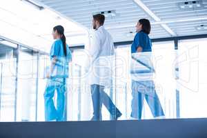 Doctor with nurses walking in corridor