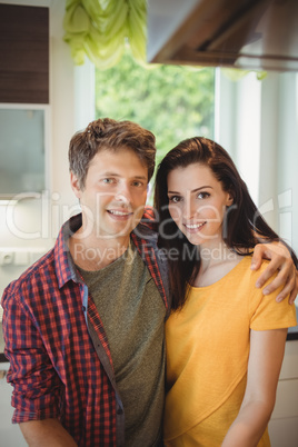 Portrait of happy couple embracing in kitchen