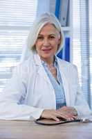 Portrait of a smiling female doctor sitting at desk