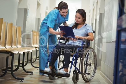 Female nurse assisting patient over clipboard