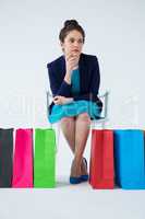 Woman sitting with colorful shopping bags