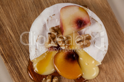 Cheese topped with walnut, fruits and sauce