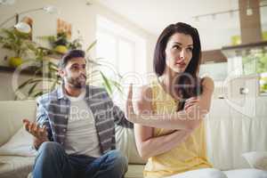 Upset couple arguing with each other on sofa