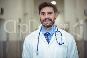 Portrait of male doctor standing in corridor