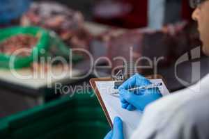 Technicians maintaining records on clipboard