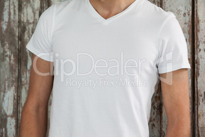 Man in white t-shirt against wooden background