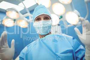 Portrait of female surgeon wearing surgical mask in operation theater