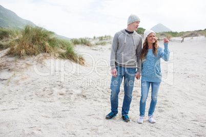 Happy mature couple pointing at view