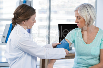 Female doctor checking blood pressure of a patient