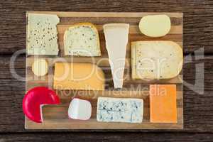 Variety of cheese on wooden board